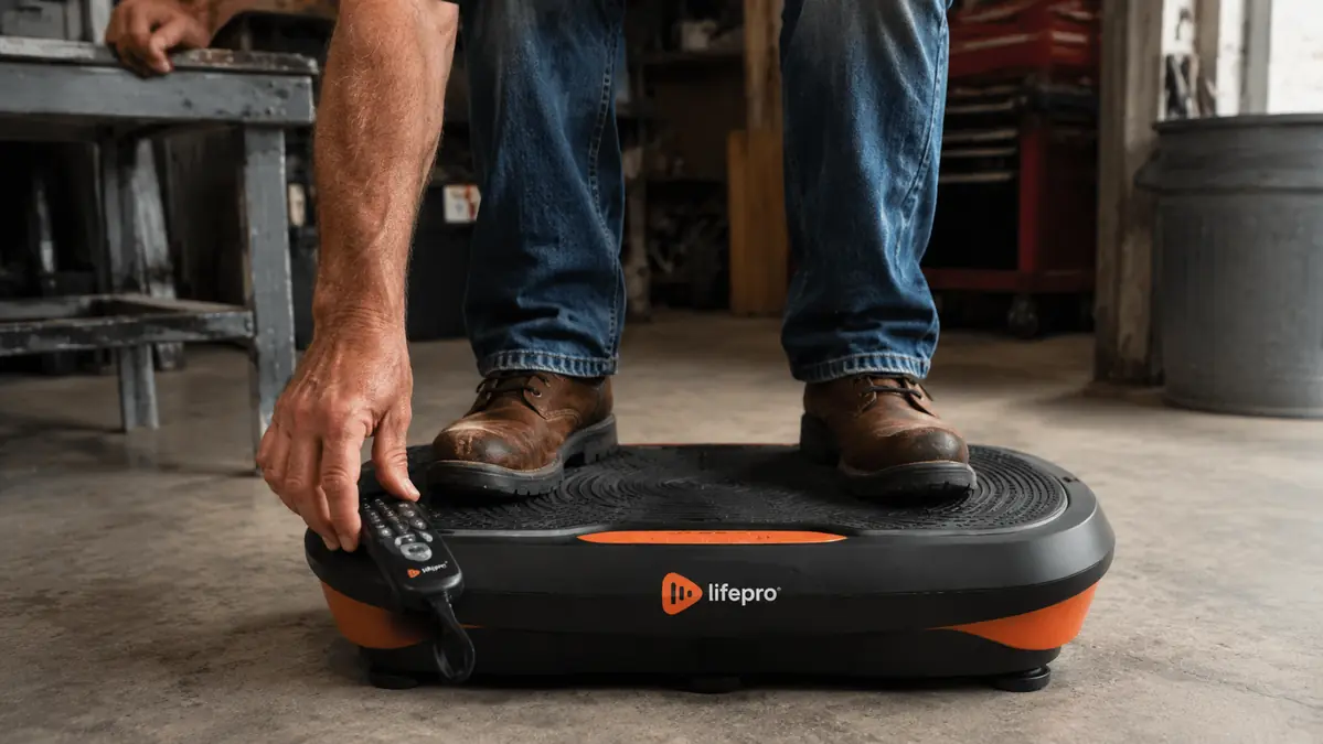 Close-up of bare feet planted on a vibration plate platform with the remote control visible nearby
